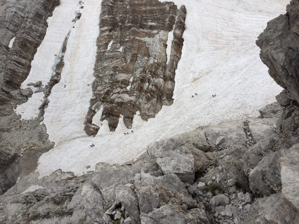 The team victoriously sliding down the snow after via ferrata adventures back to our refuge!